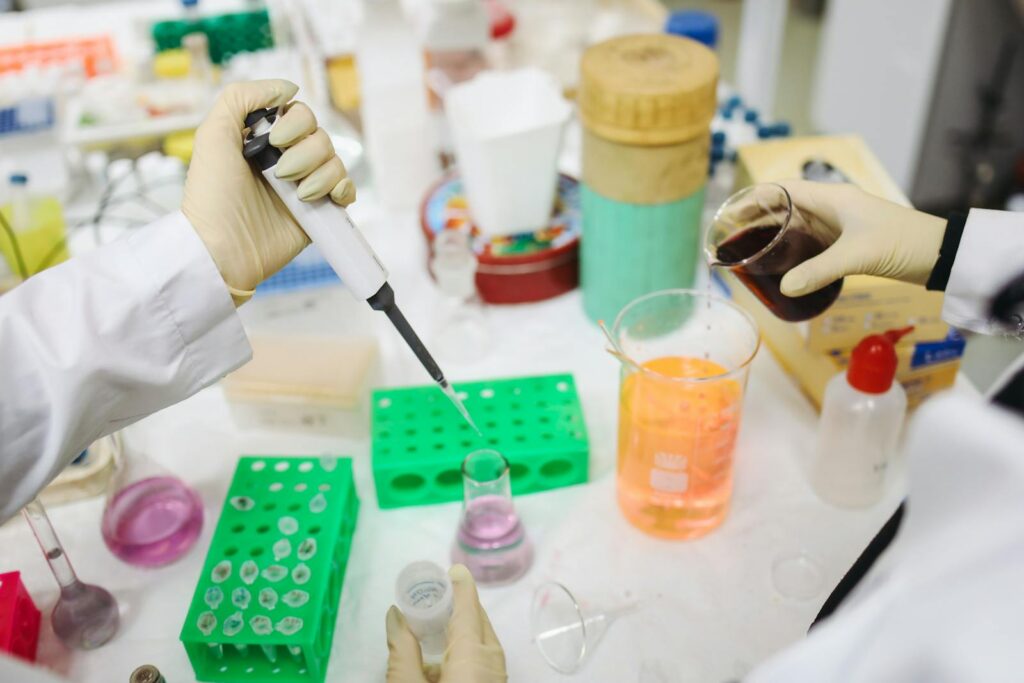 Scientists conducting an experiment with chemicals and tools in a modern lab setting.